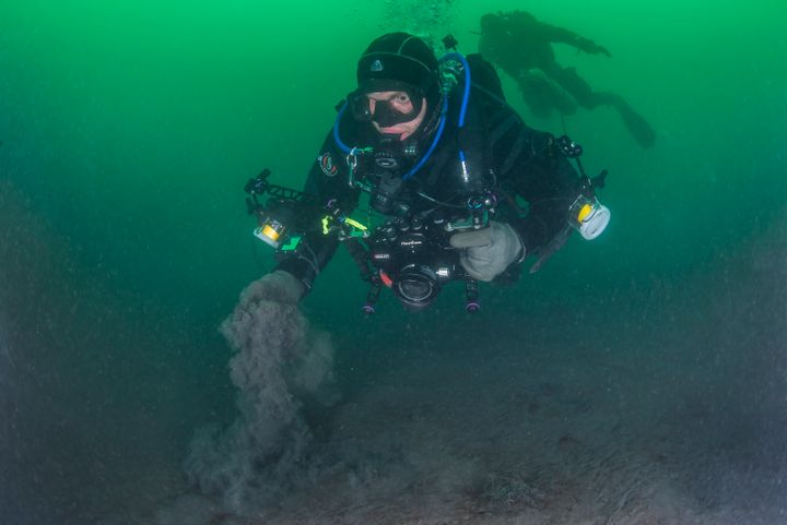 Dykker graver opp gruveavfall fra sjøbunnen i Jøssingfjorden.