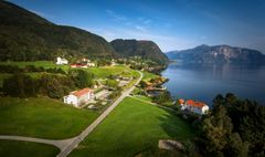 Bygda Vevring med Engebøfjellet og Førdefjorden i bagrunnen.