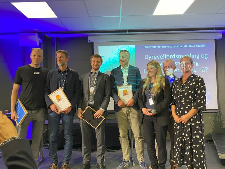 Fiskevelferdsprisen 2025 ble delt mellom AkvaFuture og Cermaq, Eide Fjordbruk og Salmar for å ha slutta med rensefisk. Her er vinnerne fra venstre: Sondre Eide fra Eide Fjordbruk, Anders Fjellheim fra Salmar, Thomas Myrholt fra AkvaFuture og Snorre Jonassen fra Cermaq. Ved siden av han er Stine Gismervik fra Veterinærinstituttet, Pål Mugaas Jensen fra OceanSpace Media (Kyst.no) og Solveig Holm fra NCE Seafood Innovation. Foto: Tom Haavardstun, Veterinærinstituttet