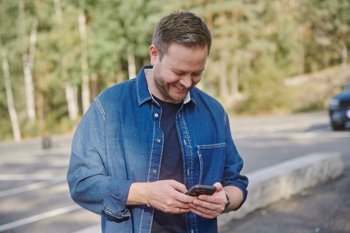 Mann som leser SMS på mobiltelefon