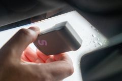 Hånd som fester bombrikke i frontruta på en bil