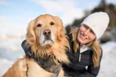 Portrett av en kvinne og golden retriever ute i vintersolen