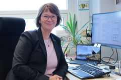 Fotografi av professor Lise Øvreås. Tatt på kontoret hvor Øvreås sitter på en kontorstol vedsiden av datamaskin.