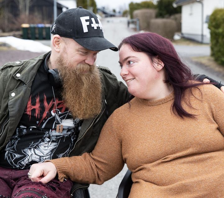 Bilde av Helge og Silje som begge sitter i rullestoler ved siden av hverandre, og som ser hverandre i øynene.
