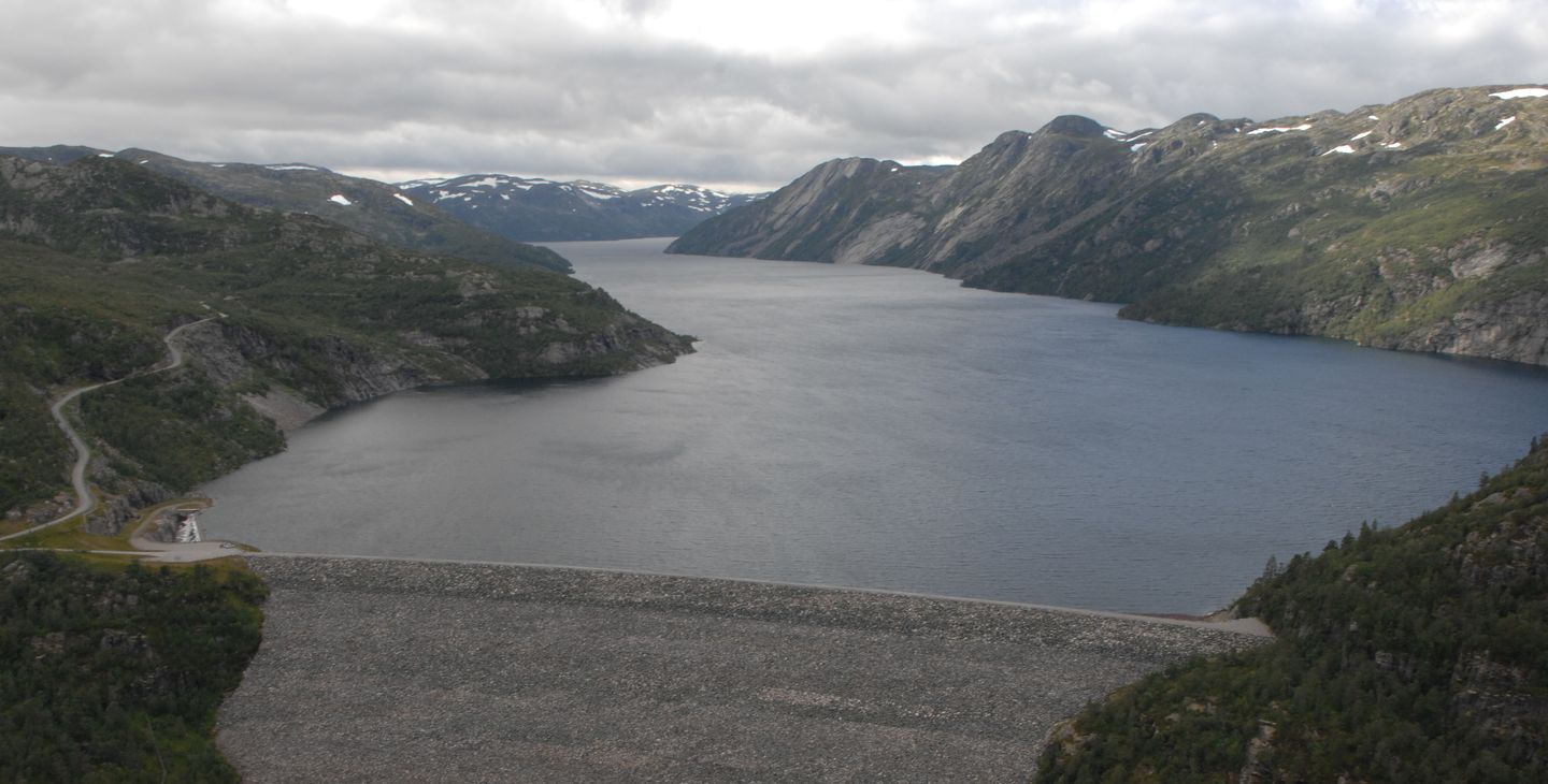Dam, vann, himmel, fjell. Foto.