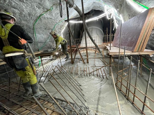 Byggeplass, arbeidsfolk, betongstøping. Foto.