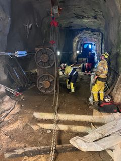 Anleggsarbeidere i arbeid inne i fjelltunnel. Foto.