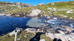 Fjellterreng, bekk, grus. Foto.