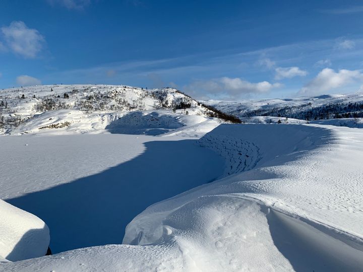 Snø, dam, fjell, himmel, skyer. Foto.