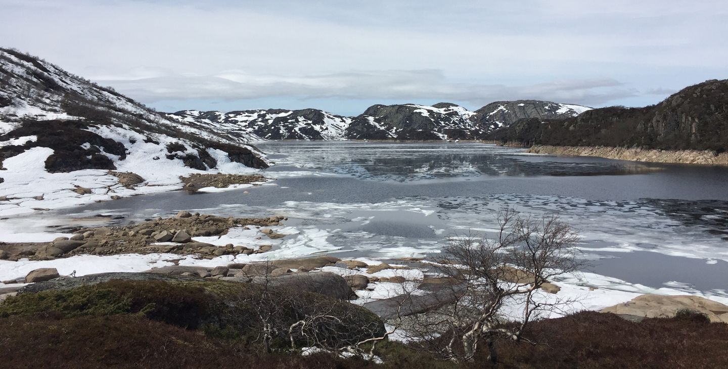 Fjell, snø, vann, himmel, skyer. Foto.