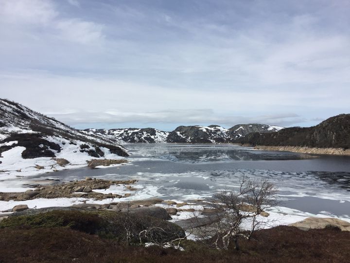 Fjell, snø, vann, himmel, skyer. Foto.