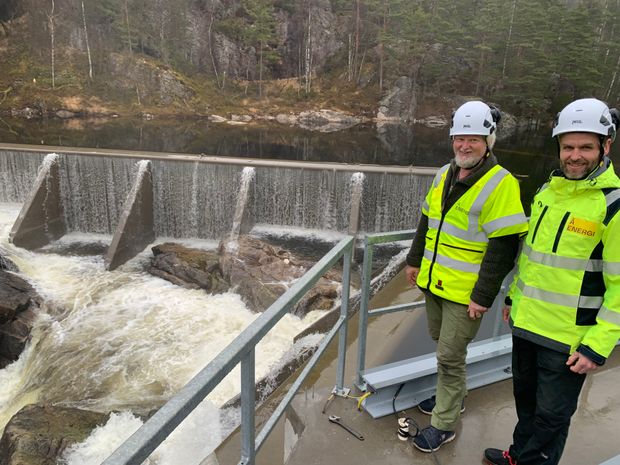 Dam, vann, to mennesker i vernetøy. Foto.