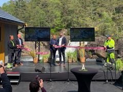 Kraftverk, vann, skog, fem menn på en scene, snorklipping. Foto.