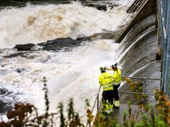 Vann, dam, vannkraftverk, to personer i vernetøy. Foto.