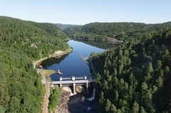 Dam, vann, skog, himmel. Foto.
