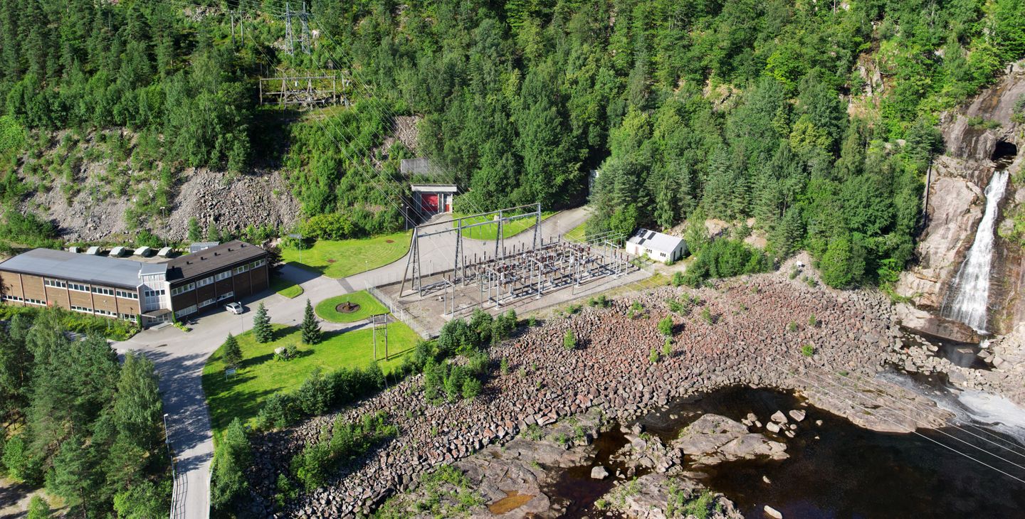 Kraftverk, vann, skog, vei. Foto.