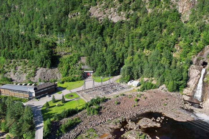 Kraftverk, vann, skog, vei. Foto.