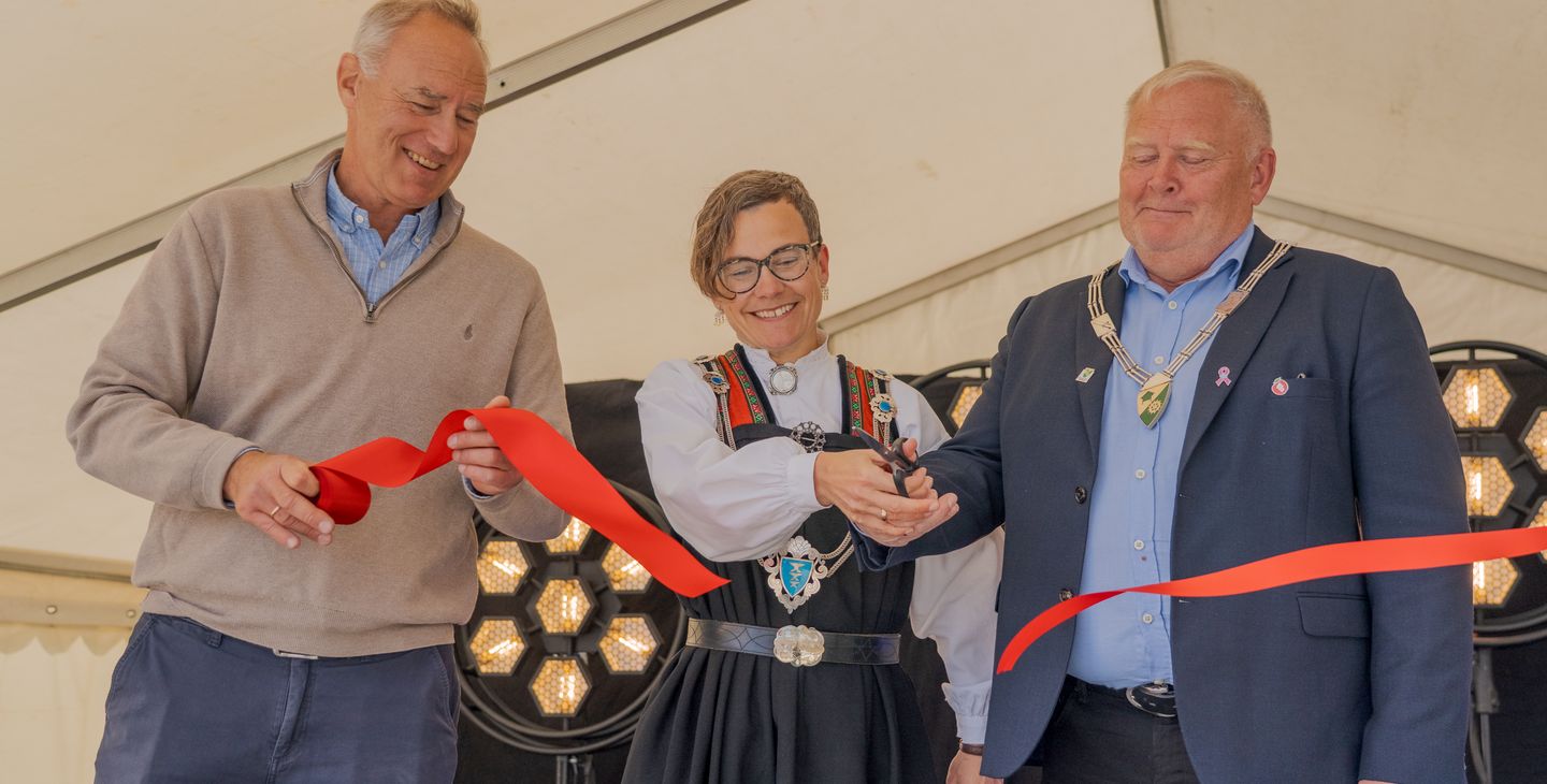 Tre mennesker, rødt sløyfebånd, ordførerkjeder.