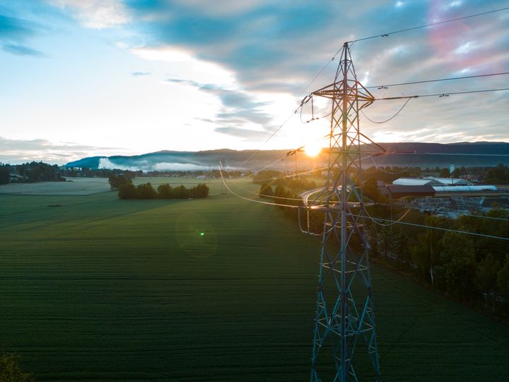 Strømnett, jordbruksareal, himmel, skyer. Foto.