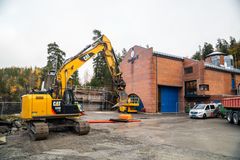 Kraftverksbygg, gravemaskin, anleggsutstyr, biler. Foto.