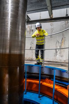 Mann, vernetøy, turbin, kraftverk. Foto.