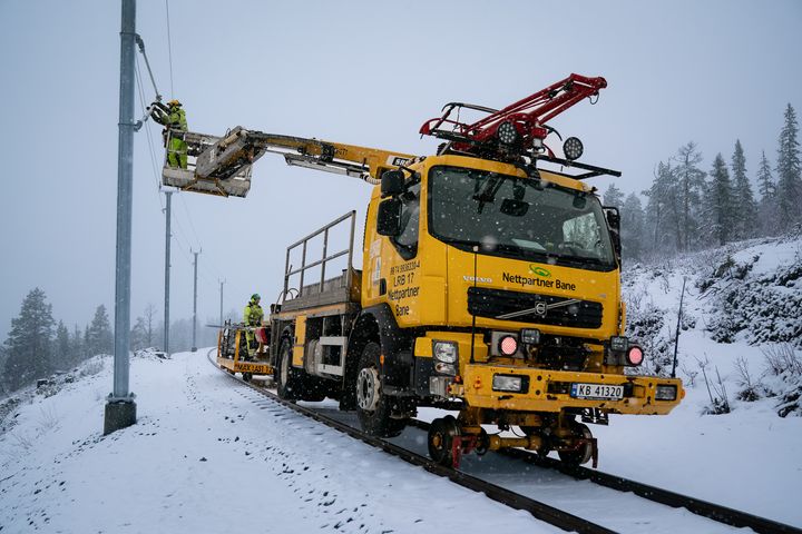 Anleggsmaskinbil, lift, jernbane, snø. Foto.