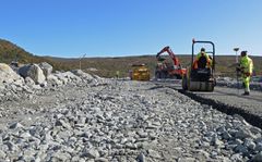 Anleggsarbeid, anleggsmaskin, dam, fjell, himmel. Foto.