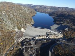 Dam, vannmagasin, fjell, himmel. Foto.