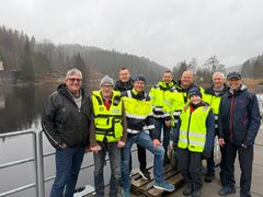 Gruppe mennesker, elv, skog, himmel. Foto.