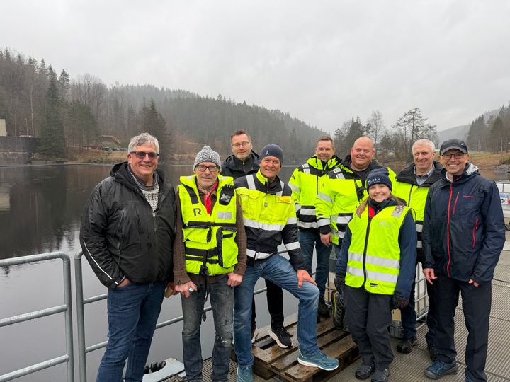 Gruppe mennesker, elv, skog, himmel. Foto.