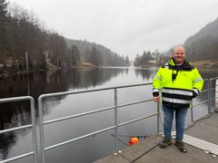 Mann, elv, skog, himmel. Foto.