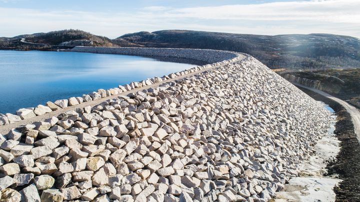 Dam, vann, skog, fjell, himmel. Foto.