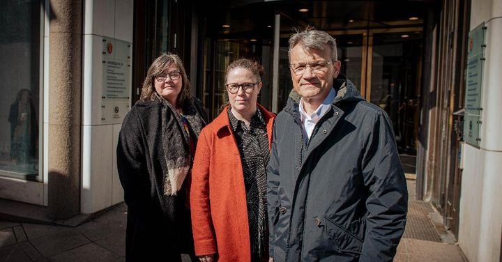 Tre personer står utenfor en bygning ved åpningen av hovedoppgjøret i staten, 22. april 2024.