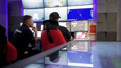 To personer i et operasjonssenter med flere skjermer viser sanntidsdata for styring av en USV, Blue Eclipse®, fra Aberdeen.