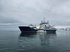 Kartverkets fartøy MS «Hydrograf» og MB «Havelle» ligger forankret i stille vann på Svalbard, med snødekte fjell i bakgrunnen.