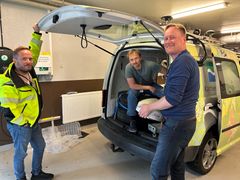Tre personer fra Kartverkets geodesidivisjon pakker utstyr som skal brukes på Jammertest, inn i en bil.