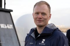 En mann i Kartverket-jakke står ute.