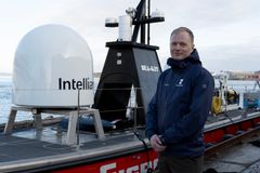 En mann står foran en stor USV i havna i Stavanger.