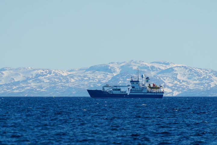 En båt, MS «Hydrograf», kartlegger dybder i Varangerfjorden. Snødekte fjell i bakgrunnen.