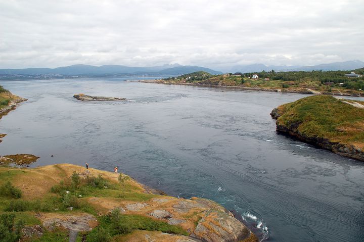 Bilde av Saltstraumen i Bodø, Nordland, med sterk tidevannsstrøm og omkringliggende landskap.