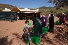 Kvinner og barn står i kø for å motta nødhjelp.