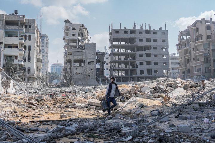 En mann går gjennom ruiner i det som tidligere var et boligområde på Gaza.