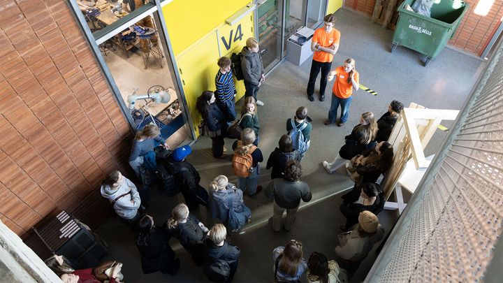 Bilde tatt ovenifra med en gruppe mennesker vendt mot to personer som prater