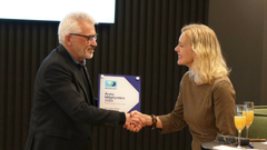 Viserektor ved UiB, Kjell-Morten Myhr, mottar diplomet for Årets Miljøfyrtårn 2025 fra Miljøfyrtårns administrerende direktør, Ann-Kristin Ytreberg.