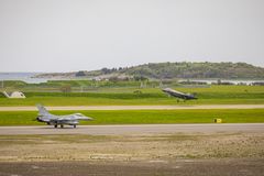 Belgisk F-16 taxer på Ørland flystasjon under Arctic Challenge Exercise 2023. I bakgrunn tar et norsk F-35 av.