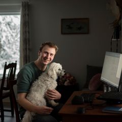 Brage Bjørnbekk i Drevdalen i Trysil fikk før jul endelig fiberlinje til hjemmekontoret, 110 km unna arbeidsplassen i Elveum. Her er han sammen med hunden Akita. Foto: Martin Fjellanger.