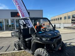 Erlend Lønnum i en Can-am ATV utenfor butikken.