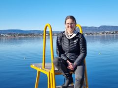 Dame som sitter på trapp ved Oslofjorden