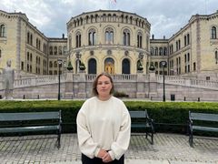 Elise Åsnes, leder i Spire, står foran Stortinget med et alvorlig ansiktsuttrykk.