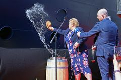 Godmother Erna Solberg throws water from Geiranger on the ship side to name Havila Pollux